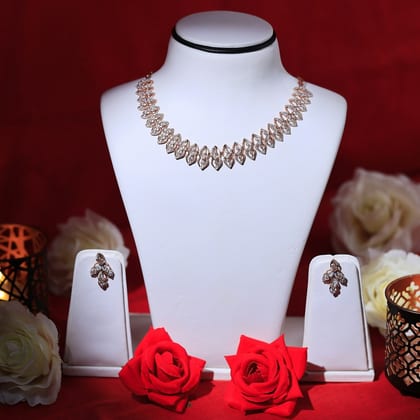 Diamond collar necklace and matching earrings on a white bust beside red roses